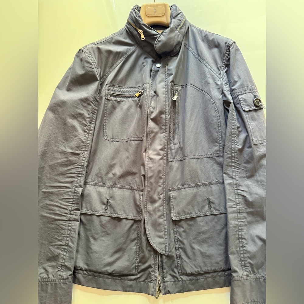 Brunello Cucinelli navy wind breaker w/enclosed hood, zipper, and snap closure.